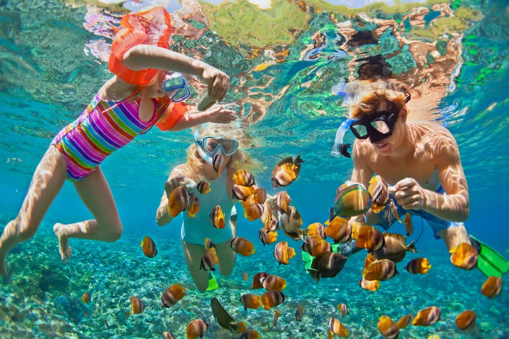 Children snorkelling with their father in Koh Yao Noi